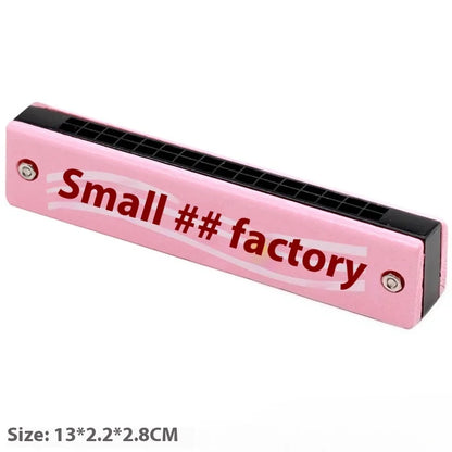 Pink plastic harmonica toy with black mouthpiece and red small factory text for preschool children beginner learning
