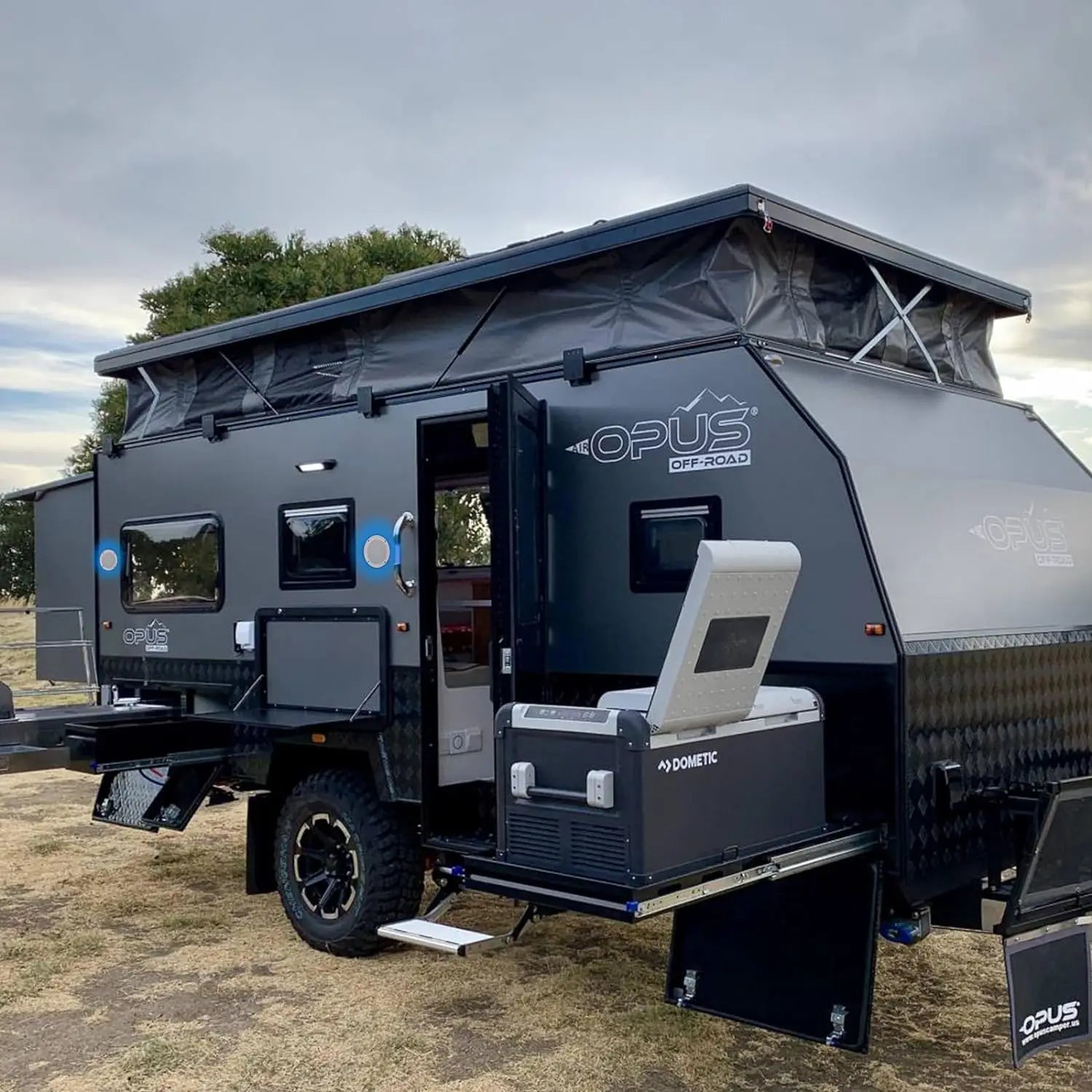 Black opus off-road camper trailer with pop-up roof and integrated dometic cooler for home outdoor camper use