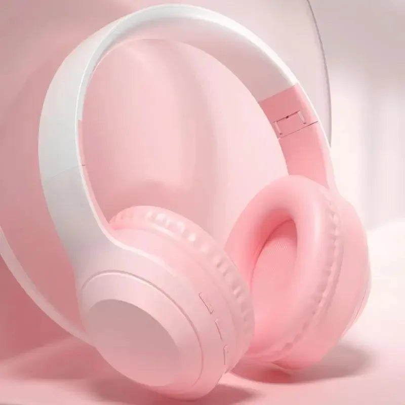 Pastel pink wireless over-ear headphones with white headband featuring noise cancelling gaming and stereoscopic surround sound