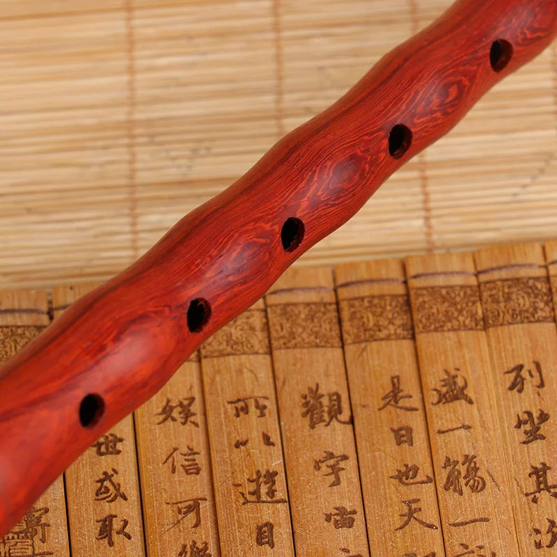 A polished red wooden musical instrument suona with five black finger holes key of G for quality Chinese folk wind musical use