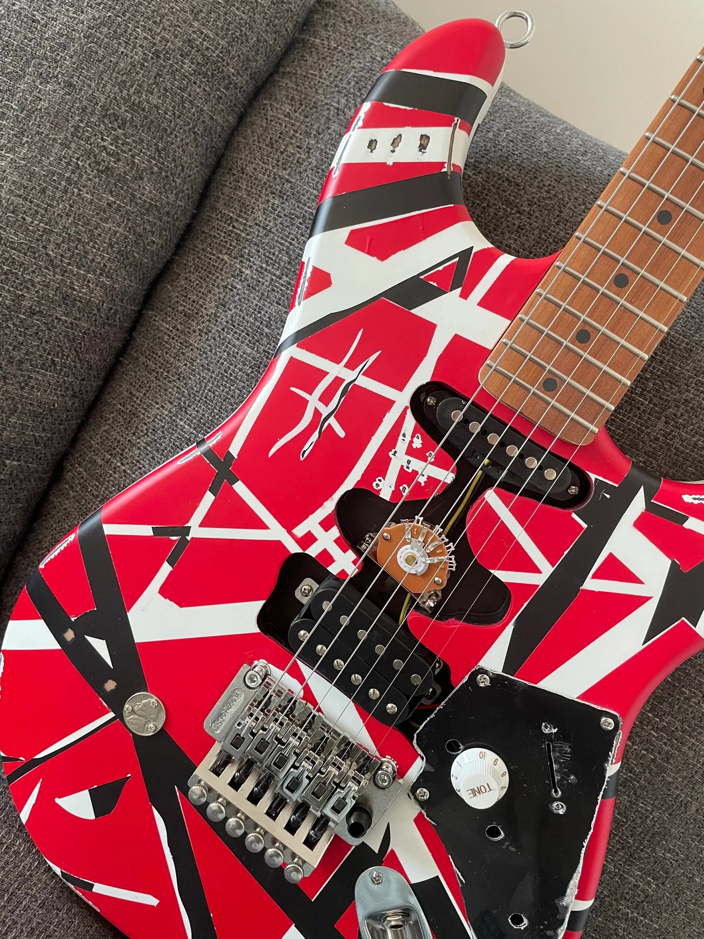 High quality red electric guitar with red black and white stripes featuring floyd rose tremolo bridge distressed design