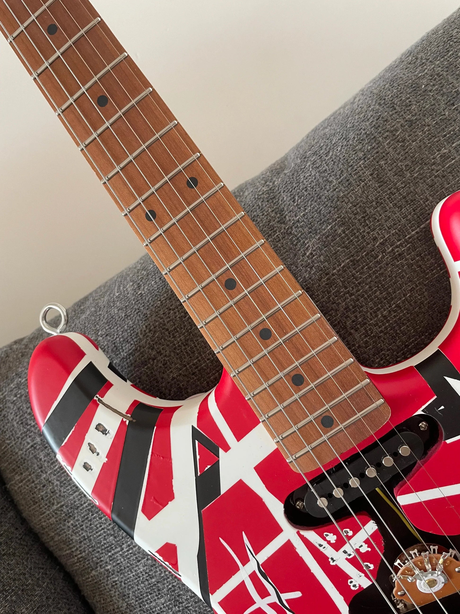 High quality red electric guitar with white and black stripes featuring a floyd rose tremolo bridge distressed finish
