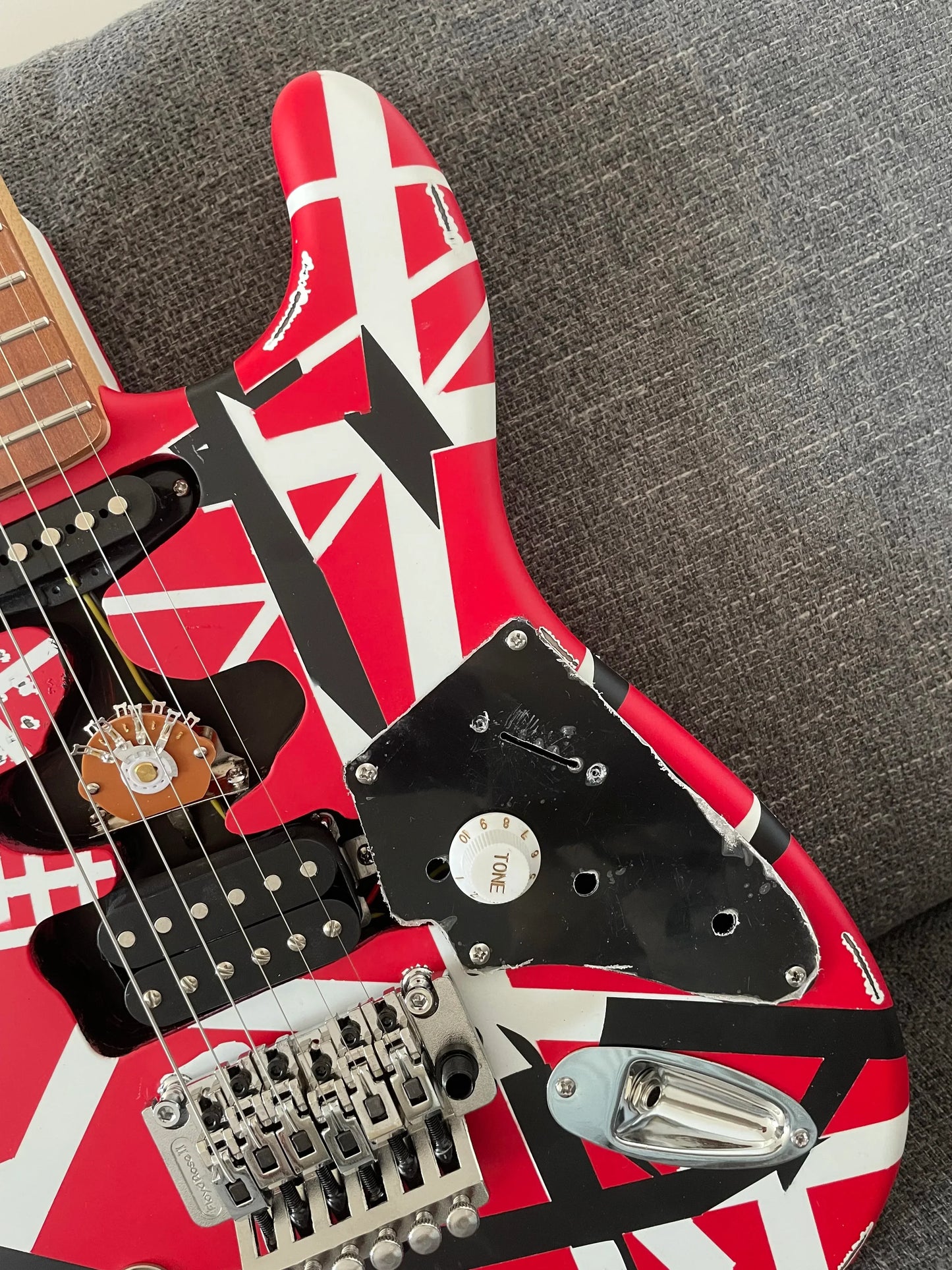 High quality red electric guitar with floyd rose tremolo and distressed tremolo bridge featuring red white and black stripes