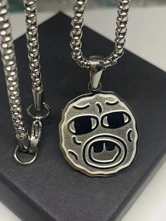 Silver-toned stainless steel hip hop necklace with round textured face and black inlaid eyes and mouth trend necklace rapper fan gift