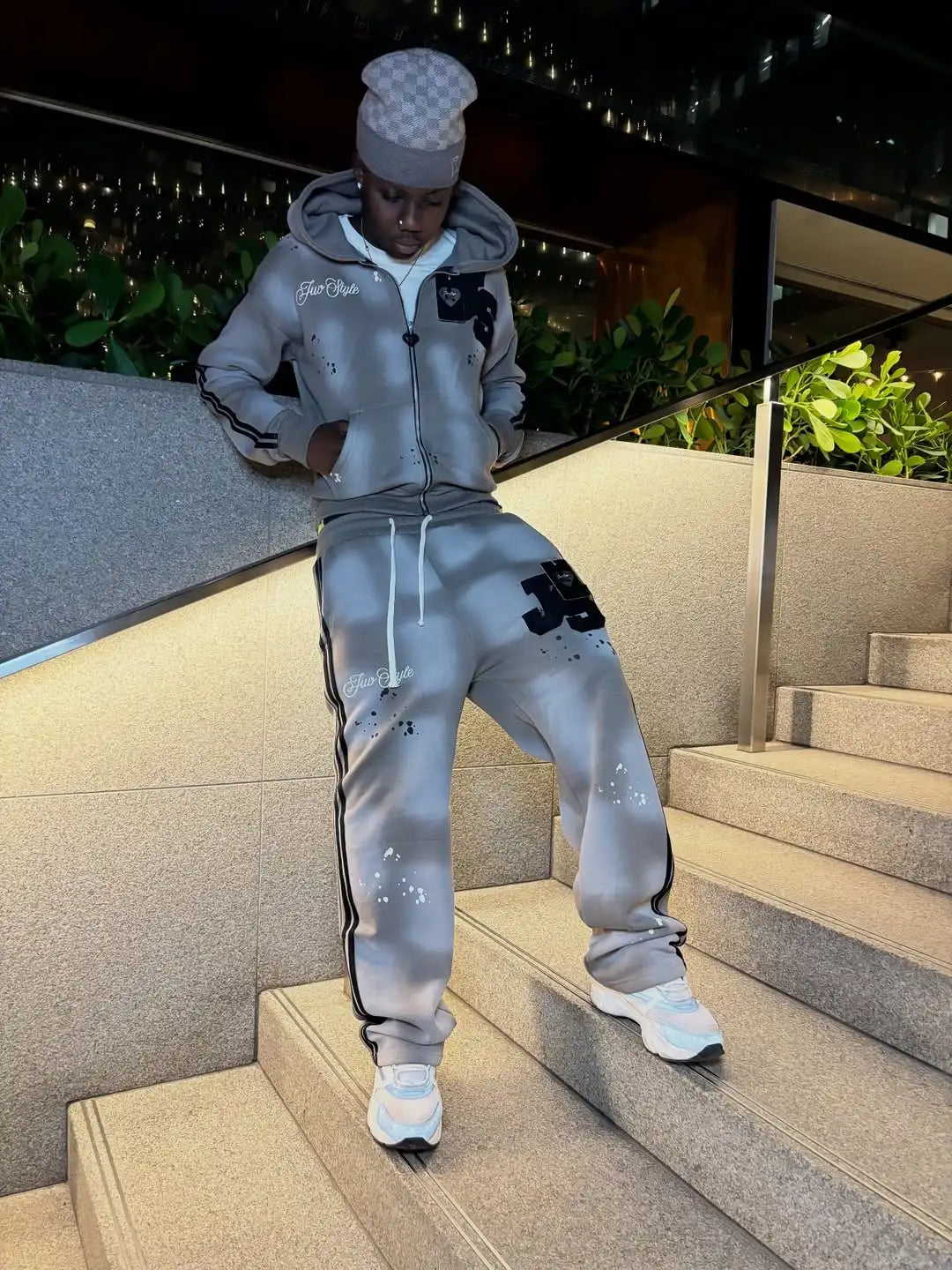 Gray sweatshirt with black splatter and white drawstrings paired with matching track pants featuring bold js logo in america style trend hip hop cool element gothic hoodies set