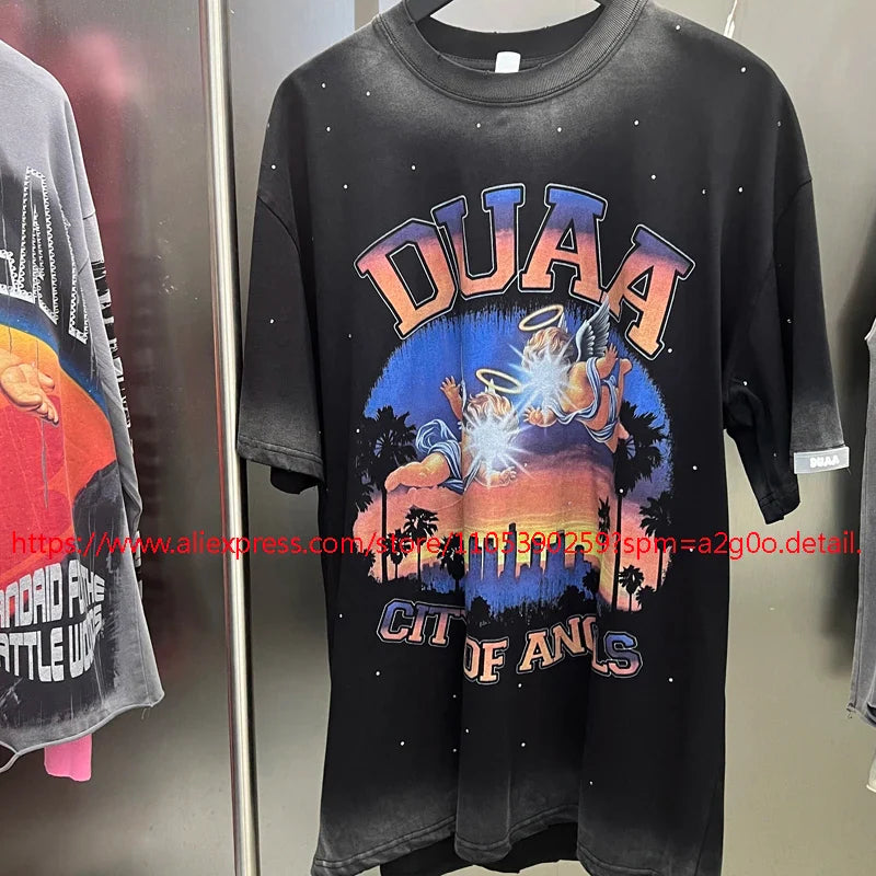 Black oversized short-sleeved duaa t-shirt with distressed retro washed fabric and vibrant angel graphic design