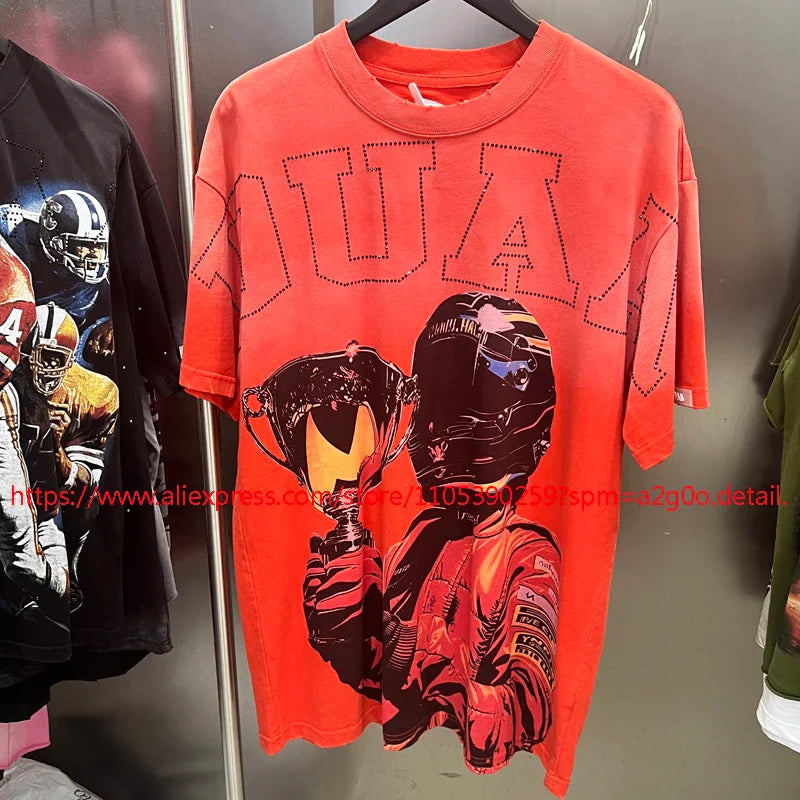 Vibrant orange oversized short-sleeved t-shirt with bold black and red racing driver graphic and stitched quan lettering
