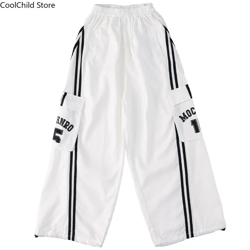 White hip hop boys cargo pants with black vertical stripes and lettering on pockets for cool graffiti dance wear