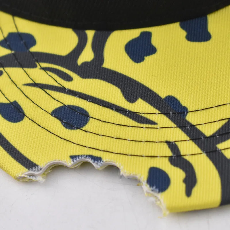 Yellow cap flat hat with bold black and navy abstract cute embroidery pattern and visible stitching on fashion flat brim