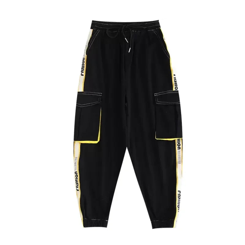 Black cargo pants with bold yellow and white side stripes, large patch pockets, and drawstring waistband for hip hop girls joggers kids streetwear