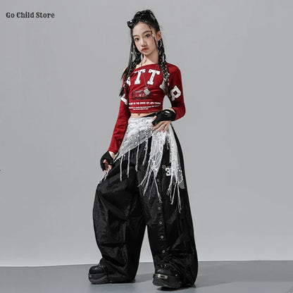 Red long-sleeved crop top with white lettering and graphic details for girl group streetwear and cargo pants kids set