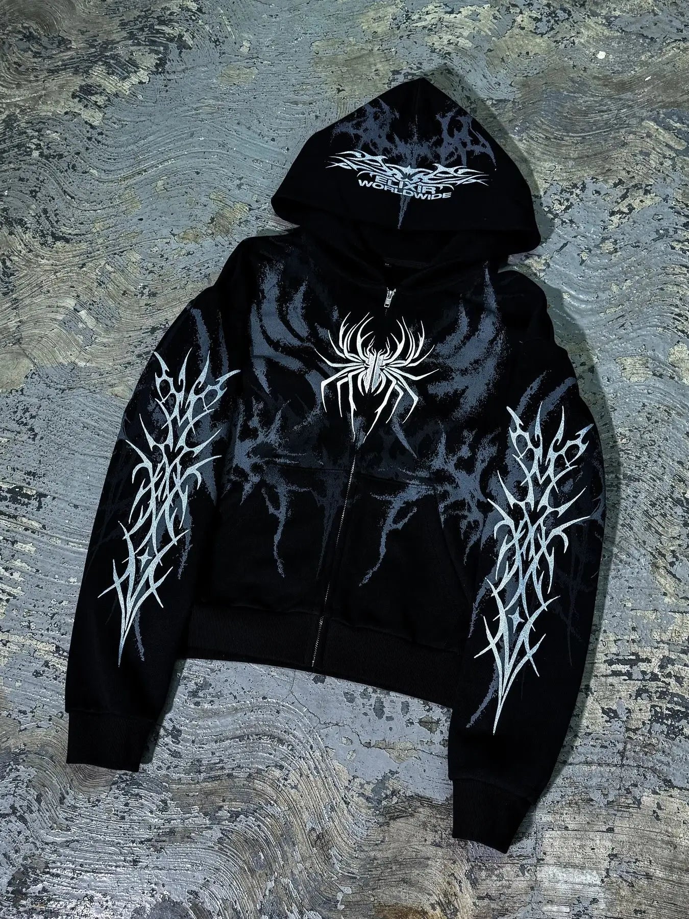 Black zip-up hoodie with bold white spider graphic and tribal sleeve designs featuring worldwide print for y2k retro streetwear