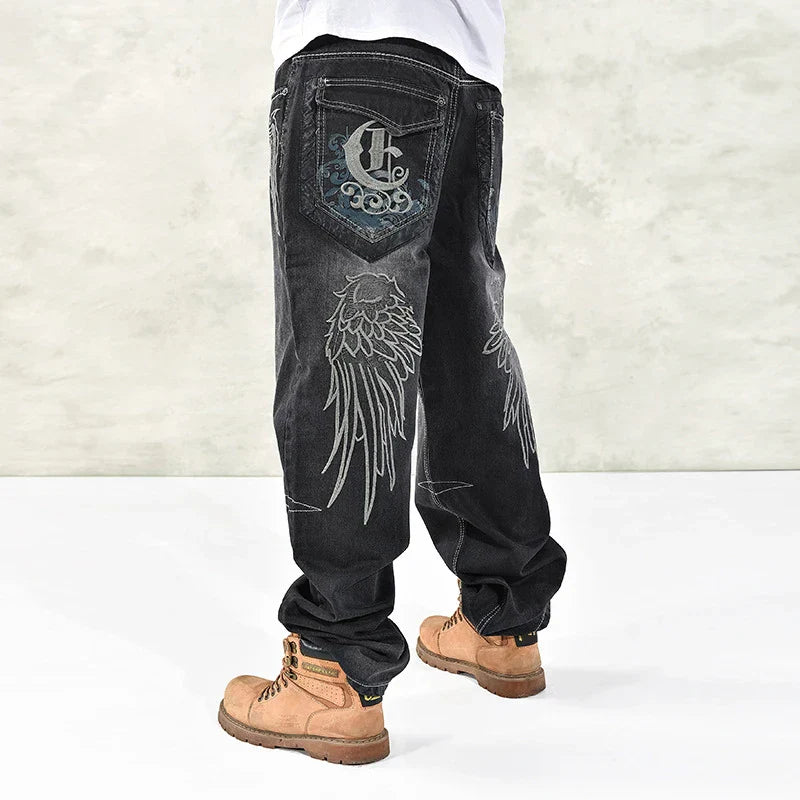 Black denim hip hop graphics embroidered jeans for men with silver wing embroidery and stylized c logo on back pocket