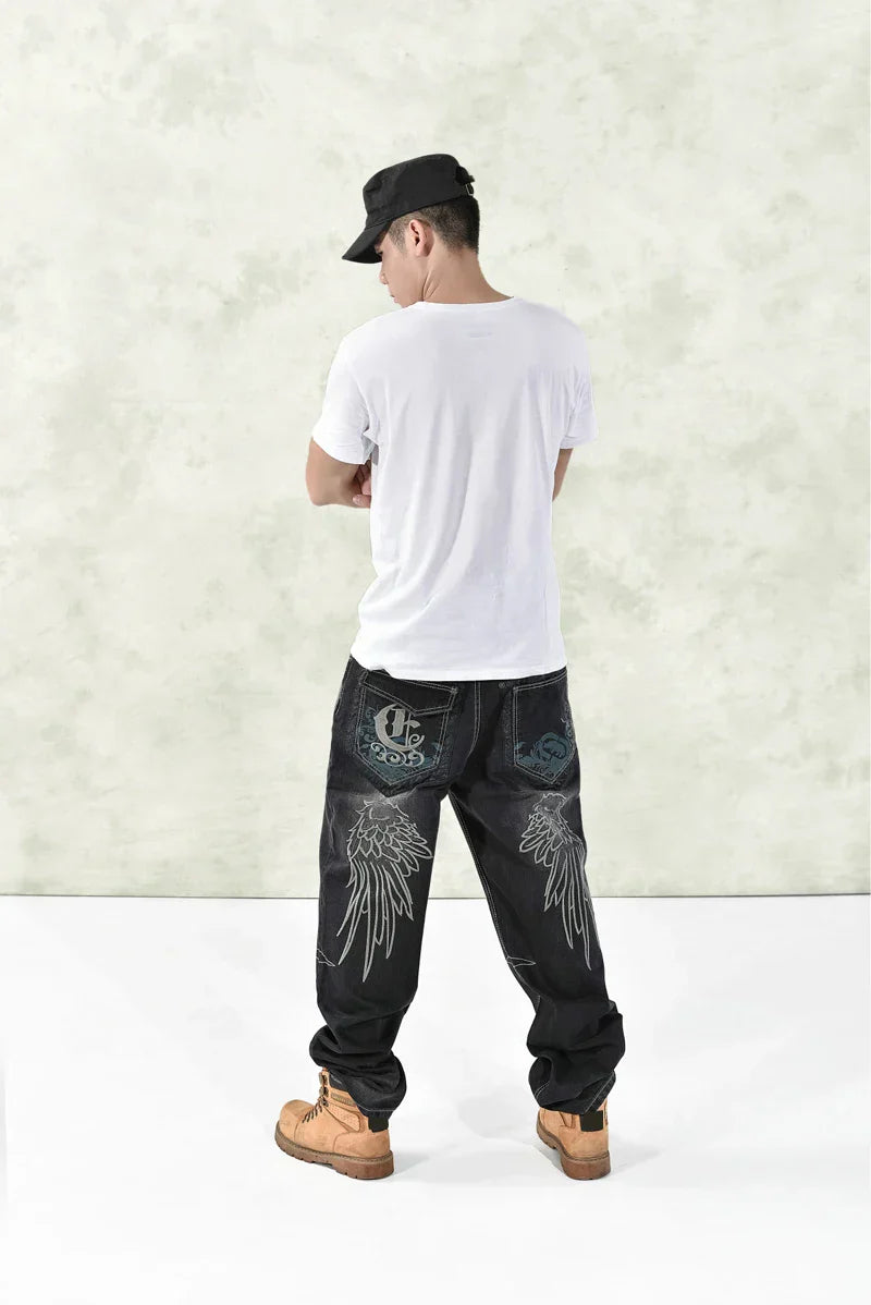 Black denim hip hop graphics embroidered jeans featuring white wing embroidery and a stylized logo patch on back pocket