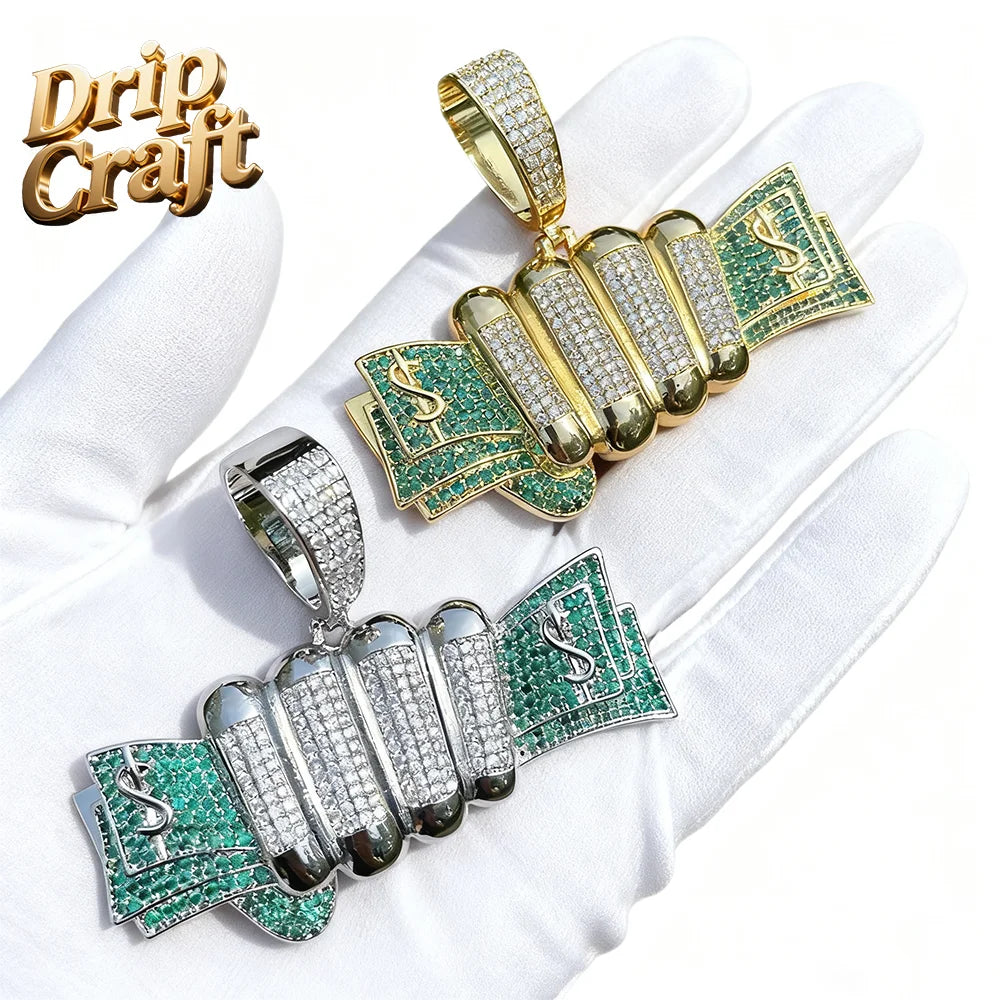 Hip-hop hand holding a dollar pendant with gold and silver dollar design, green gemstones, pave-set diamonds, and drip craft logo