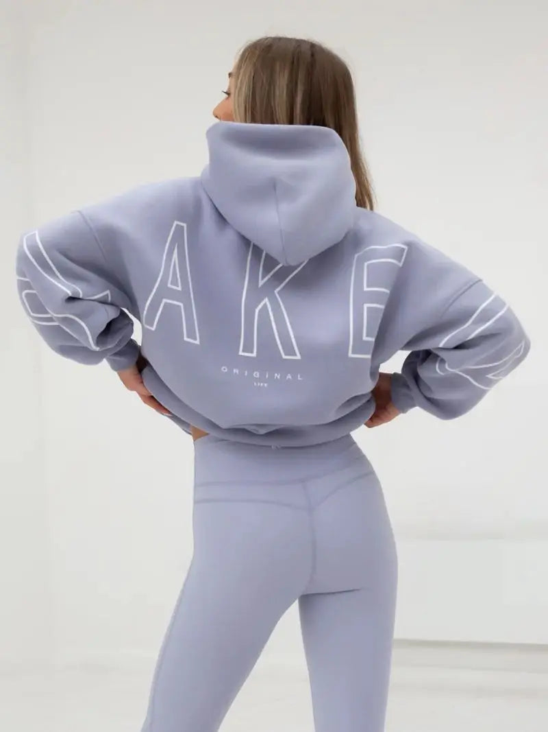 Back side of a lavender oversized hoodie men y2k with bold white outlined lettering and matching cuffs in soft fabric