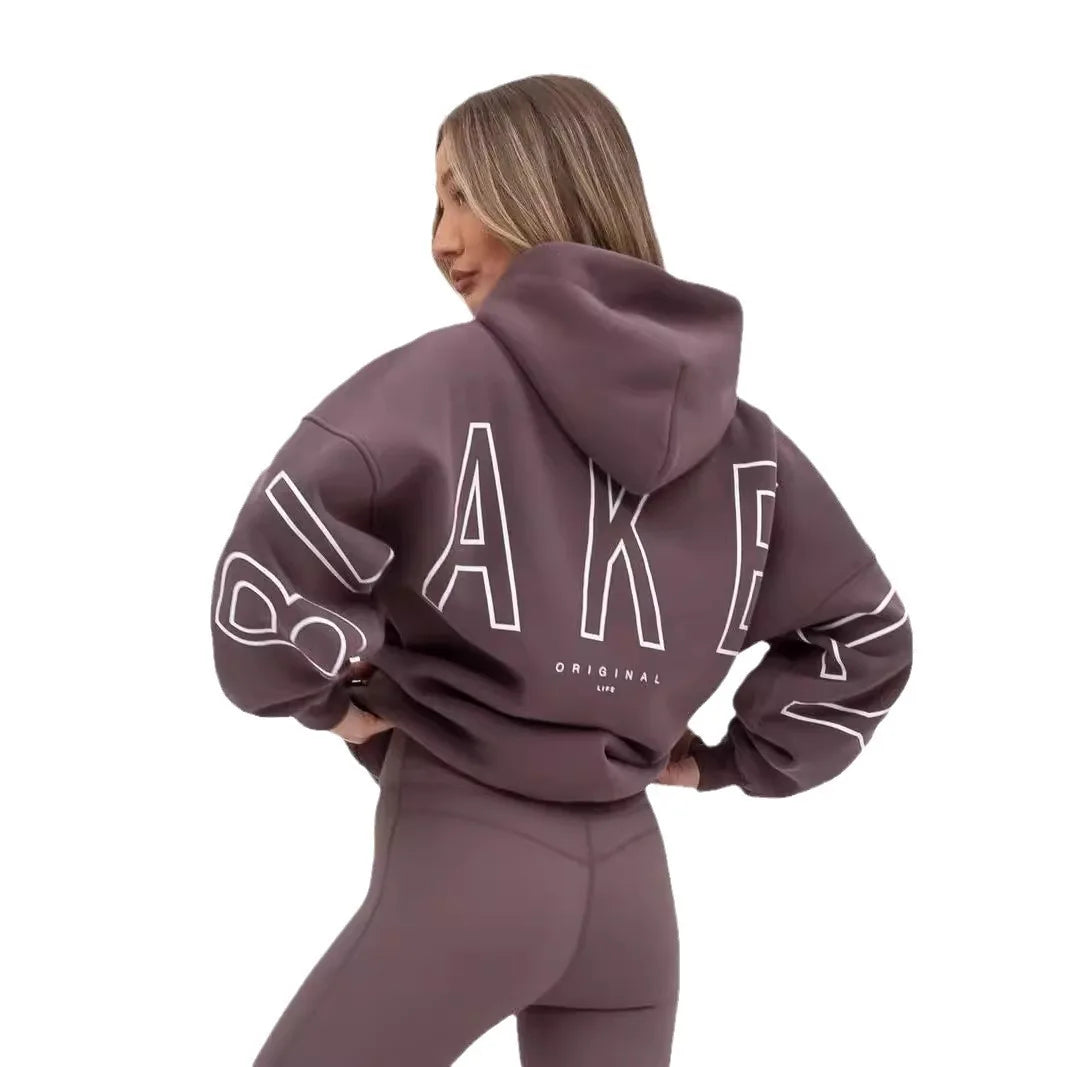A mauve oversized hoodie men y2k with bold white outlined lettering on the back and sleeves in retro gothic punk style