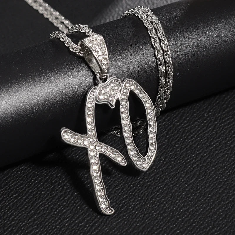 Silver rhinestone encrusted xo pendant necklace with textured chain featuring shiny cubic zirconia details for hip hop style