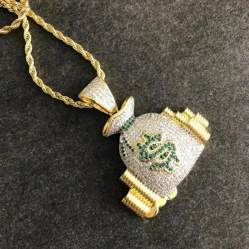 Gold chain money bag necklace with shiny cubic zirconia and green gemstones forming a dollar money bag pendant