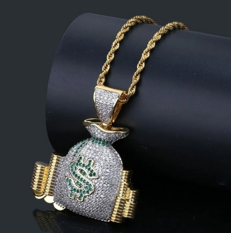 Gold-toned dollar money bag necklace with shiny white and green cubic zirconia stones for hip hop style