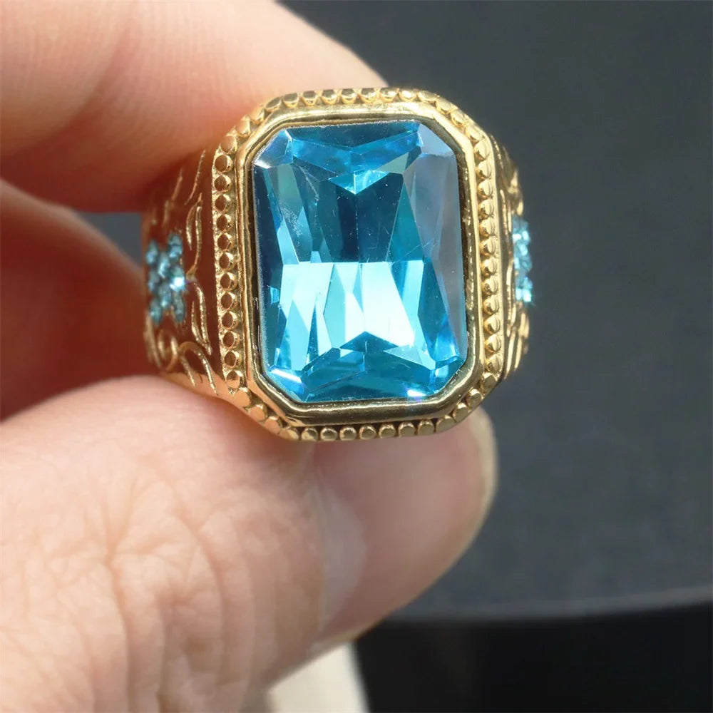 Gold color stainless steel hip hop ring with a blue cubic zirconia geometric design and iced out beaded detailing for men