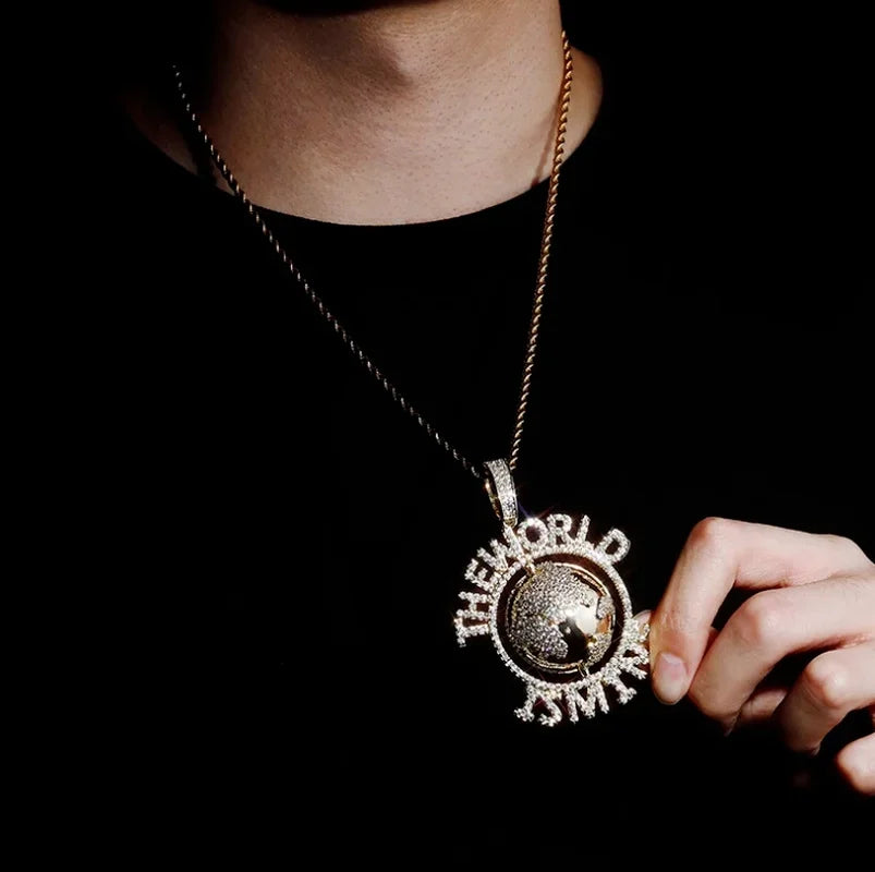 A sparkling silver hip hop letter world globe pendant with raised lettering and crystals on a tennis chain fashion necklace