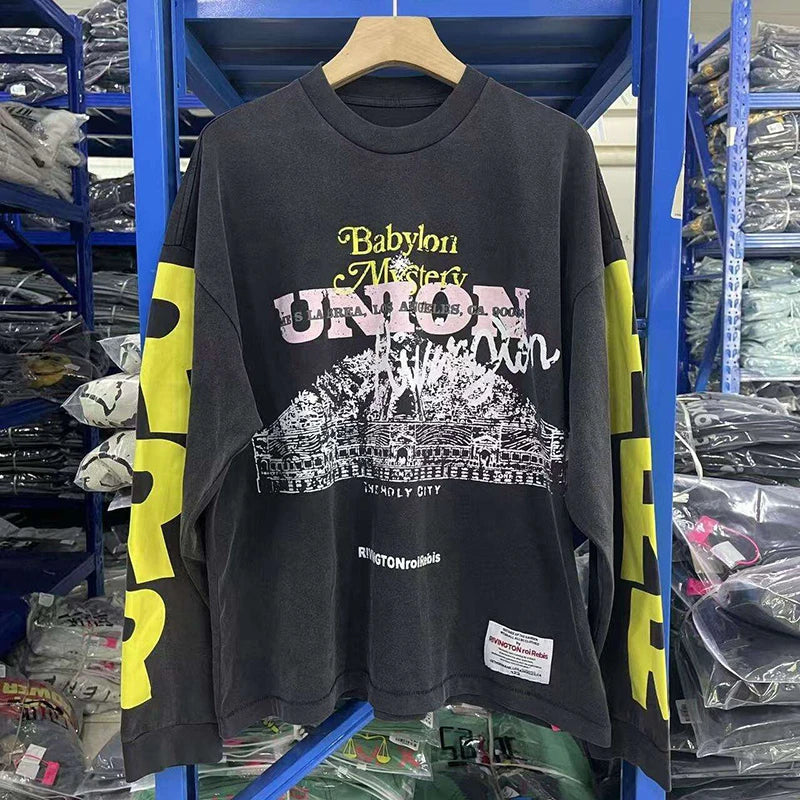 Black long sleeve cotton tee with bold yellow sleeve lettering and white babylon mystery union line-art print