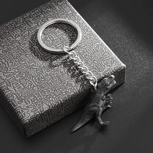 Silver-toned metal t-rex dinosaur keychain with detailed sculpting and short chain for hip-hop fashion gift