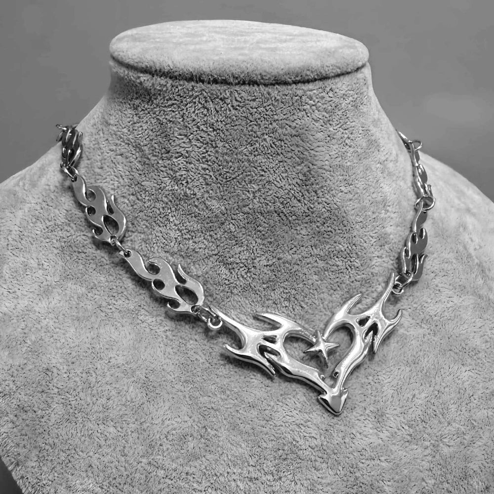 Silver flame totem necklace with a heart-shaped pendant and embedded star featuring a cross thorny chain collar design