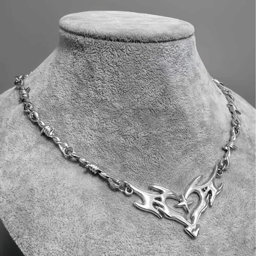 Silver chain necklace with central flame totem pendant and embedded star featuring cross thorny chain design