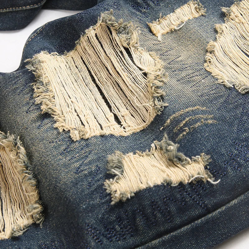 Dark blue rock motorcycle denim jeans with intentional frayed distressing and beige thread in retro american streetwear style loose straight trousers