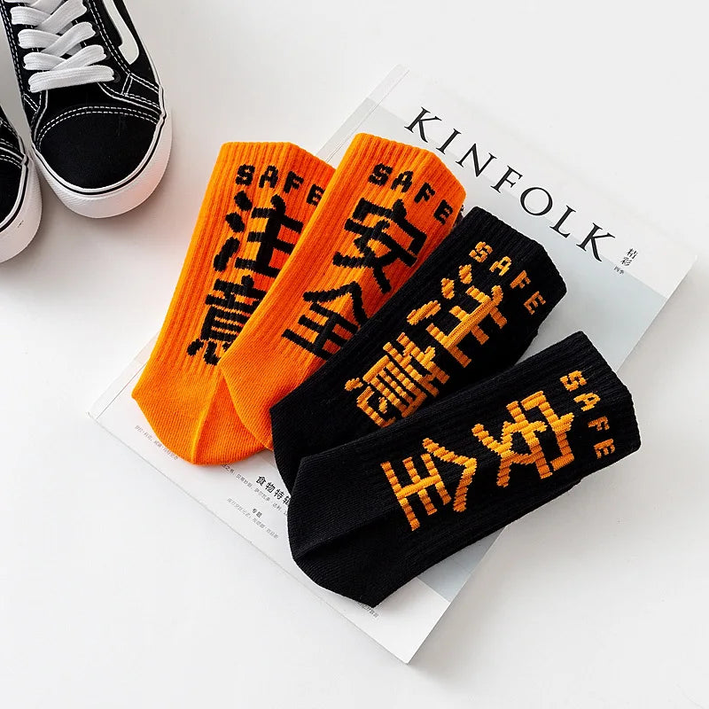 Bright orange and black harajuku tactical socks with bold pixelated safe text made of high quality cotton for casual skateboard use