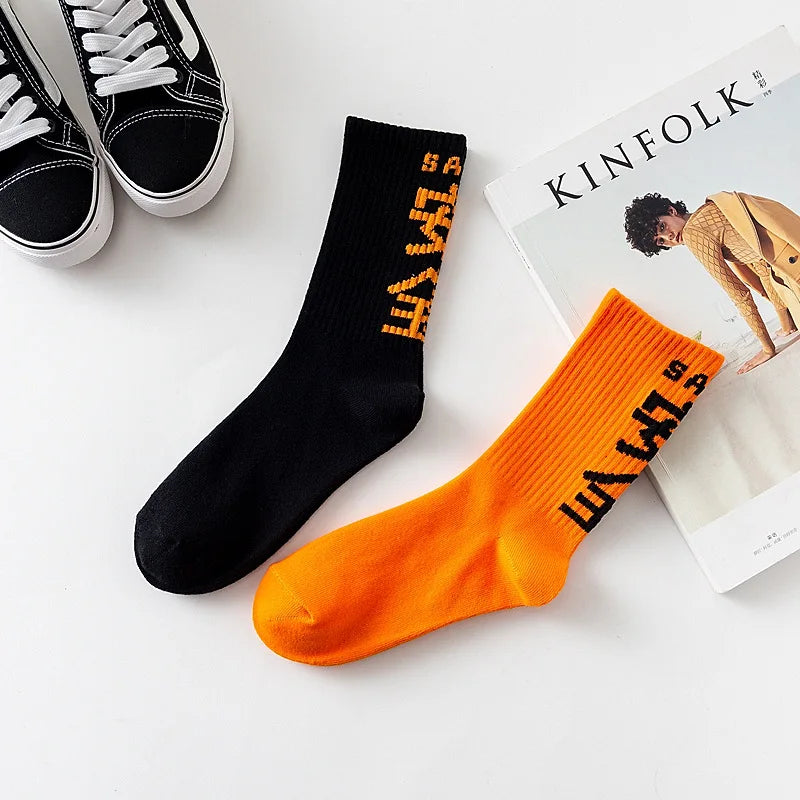 Black and orange harajuku tactical socks with bold lettering on cuff made of high quality cotton for casual skateboard use