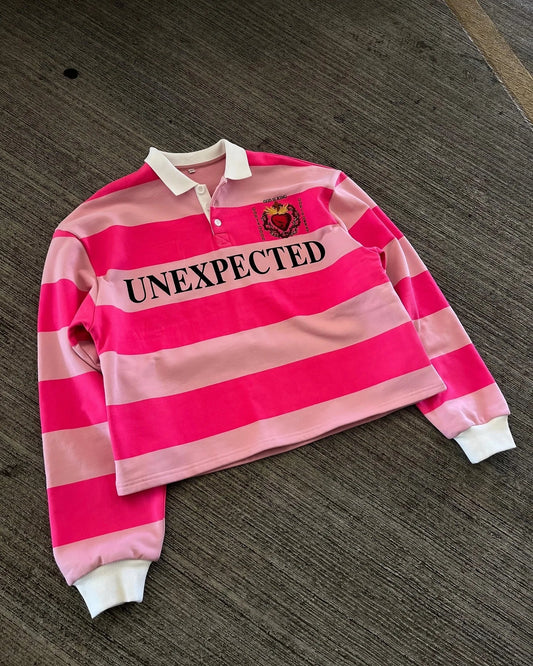 A cropped pink striped polo shirt y2k with white collar cuffs unexpected lettering and embroidered heart emblem america harajuku fashion
