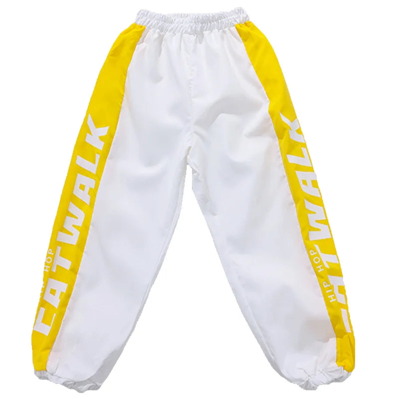 White athletic pants with bold yellow side panels featuring catwalk and hip hop lettering for kids clothing set