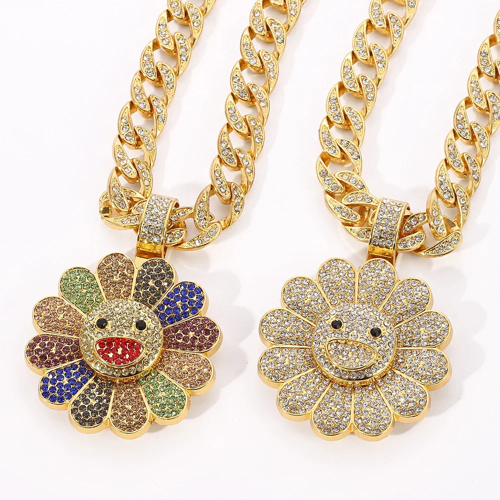 Two gold-colored takahashi sunflower pendant necklaces with diamond-encrusted zirconia petals and smiling faces