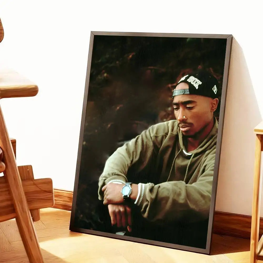 Black-framed portrait print of tupac in green hoodie and black cap with white lettering for hip hop home decor gift