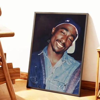 A framed hip hop poster of Tupac Amaru Shakur wearing a blue baseball cap and denim jacket for home decor