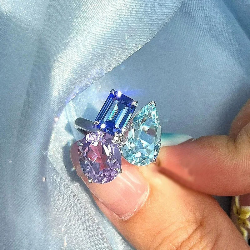 A hip hop unique silver-toned adjustable ring for women punk fashion featuring three bling zircon gemstones in blue and purple