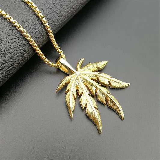 Gold-colored vintage hemp leaf pendant made of stainless steel hanging from a matching gold chain for hip hop jewelry