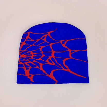 A vibrant blue wool knit beanie with a bold red spiderweb pattern for hip hop and retro autumn winter fashion