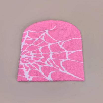 A vibrant pink wool knit beanie with a white spiderweb pattern for warm gothic hip hop fashion in autumn and winter