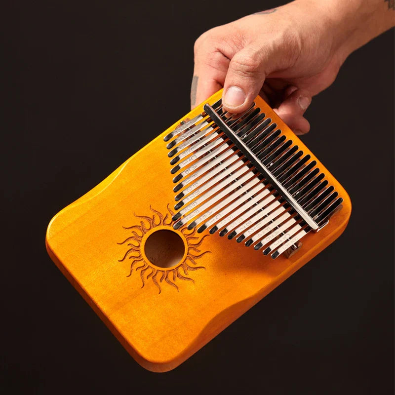Orange wooden hluru 17 key kalimba finger piano with sun-engraved sound hole and silver metal tines musical instrument mbira