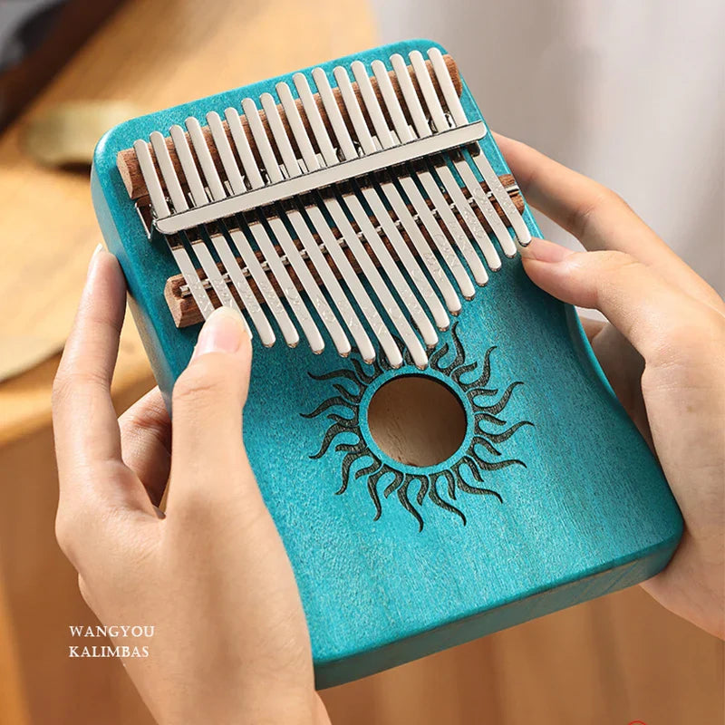 Turquoise wooden kalimba finger piano with silver metal tines and sun design for beginner music lover gifts
