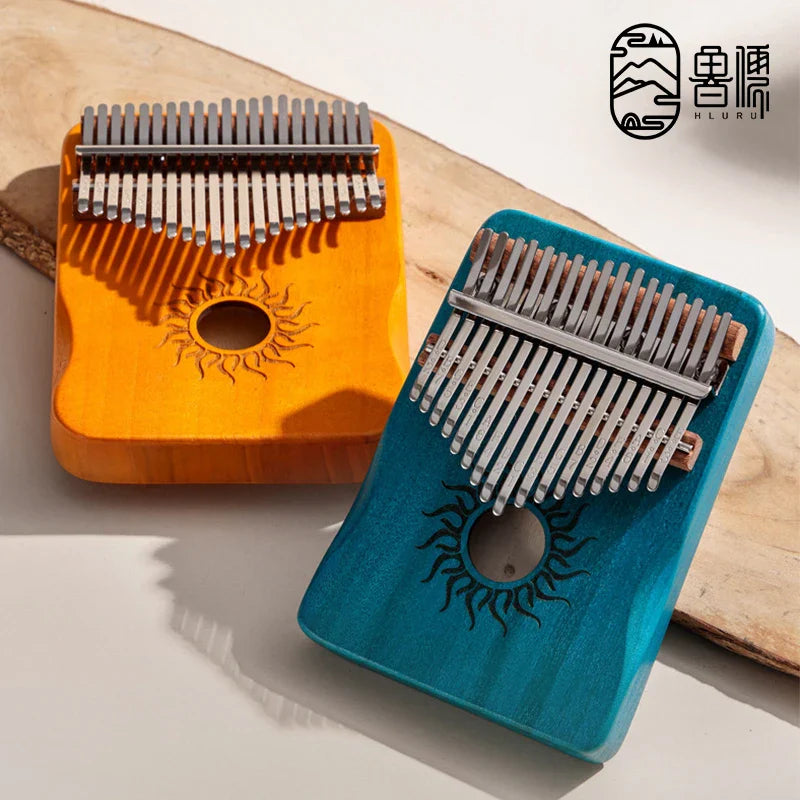 Two colorful hluru key kalimba finger pianos in orange and teal with sun design made of solid maple wood for beginners