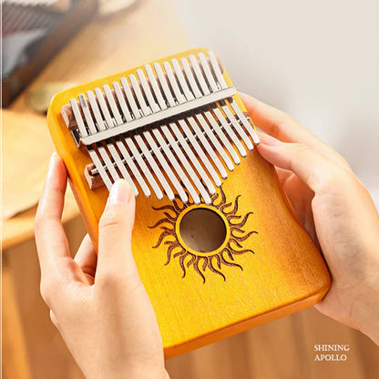 A warm yellow hluru key kalimba finger piano with silver tines sun-engraved sound hole solid maple wood thumb piano keyboard