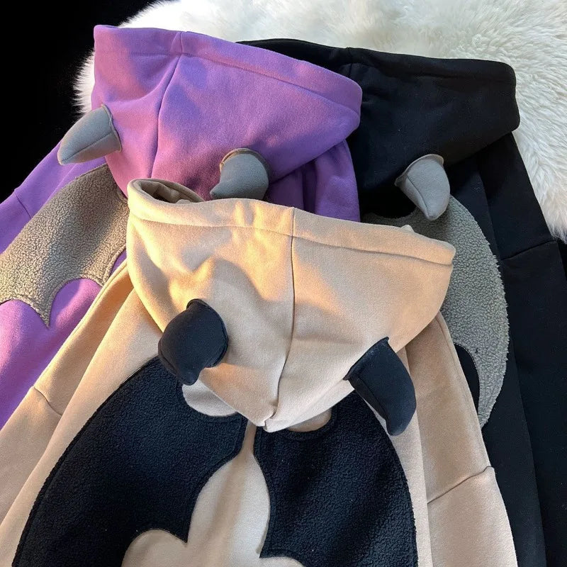 A cozy plush hoodie with bat design in soft purple beige and gray wings featuring y2k aesthetic grunge streetwear style