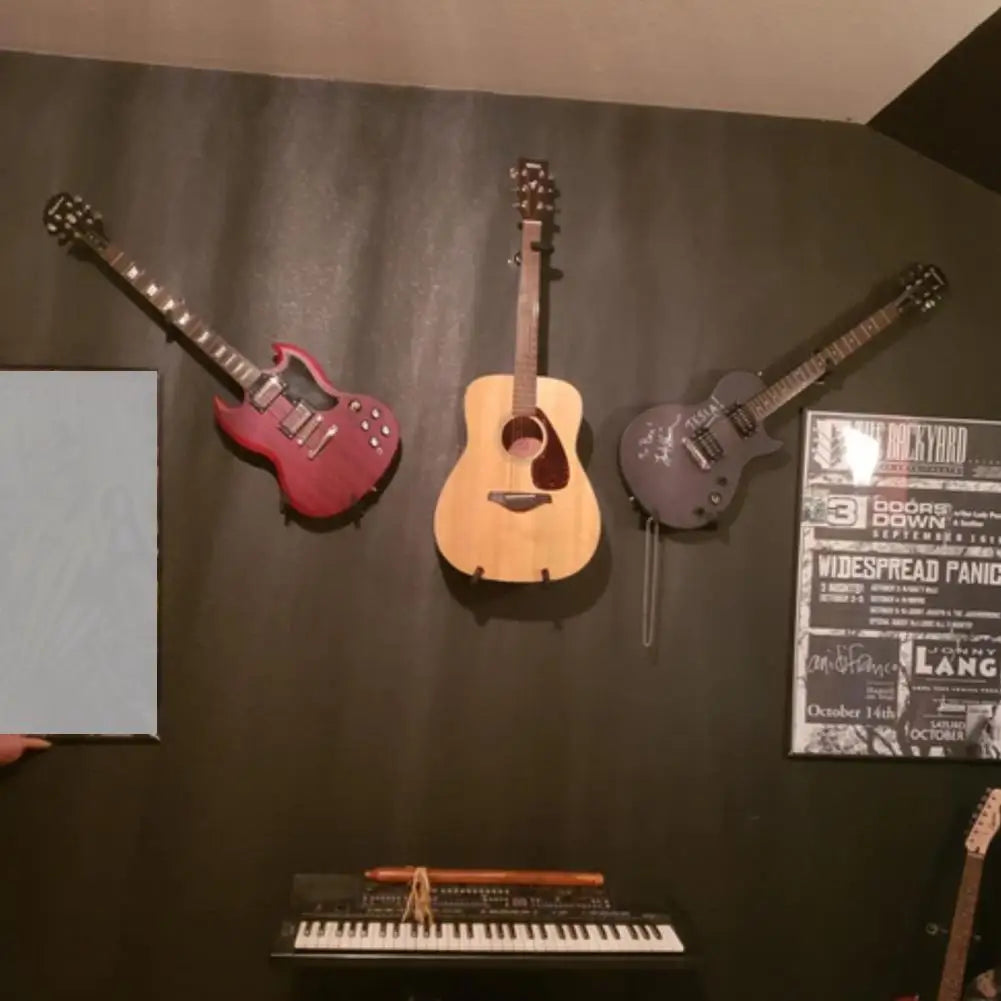Three guitars mounted on a dark wall on a horizontal metal guitar hanger stand for acoustic guitar bass mandolins slat display