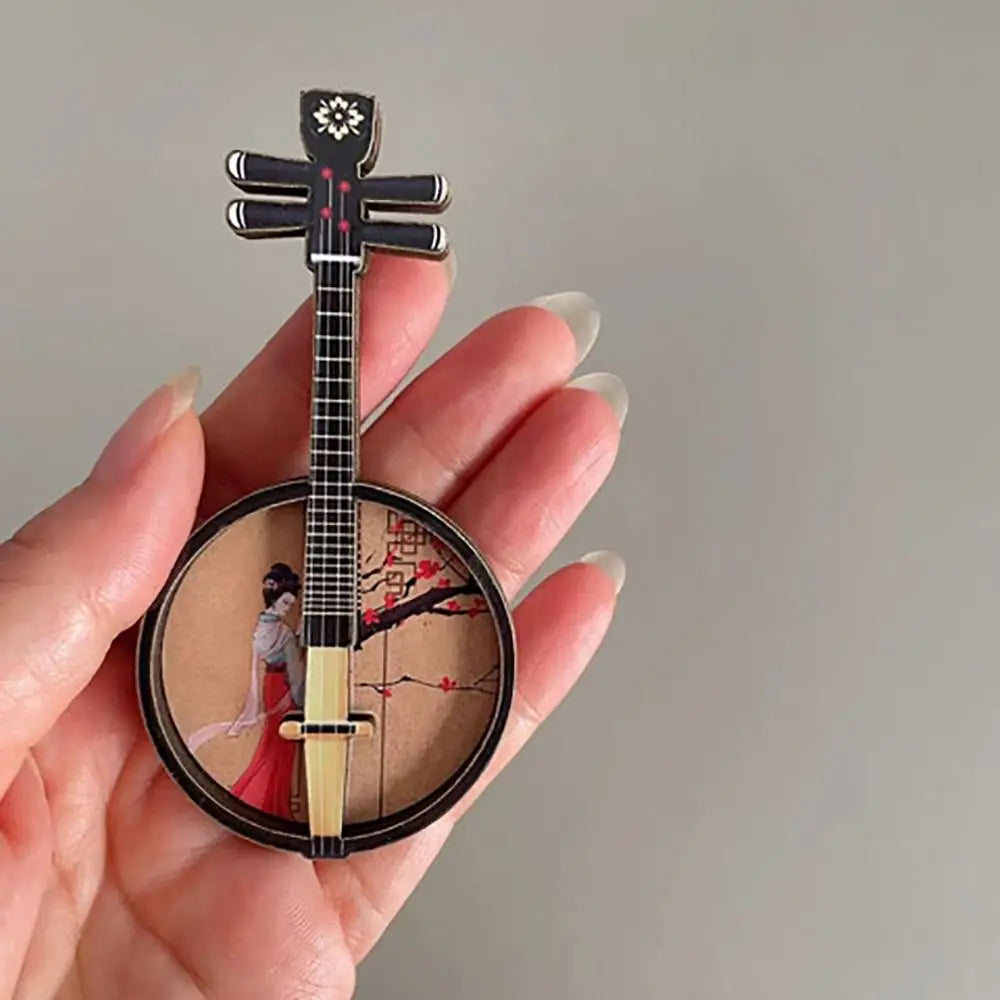 Black and gold miniature banjo pin with traditional chinese woman in red playing a chinese classical instrument courtesan pattern