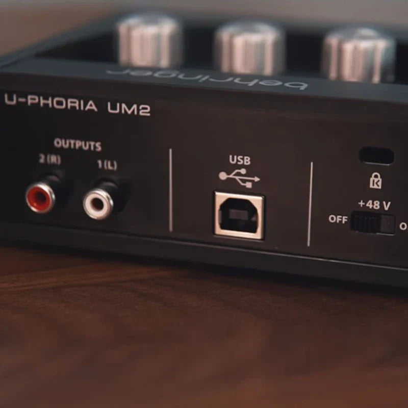 Black behringer u-phoria um2 usb audio interface with silver knobs and labeled ports for microphone amplifier live use